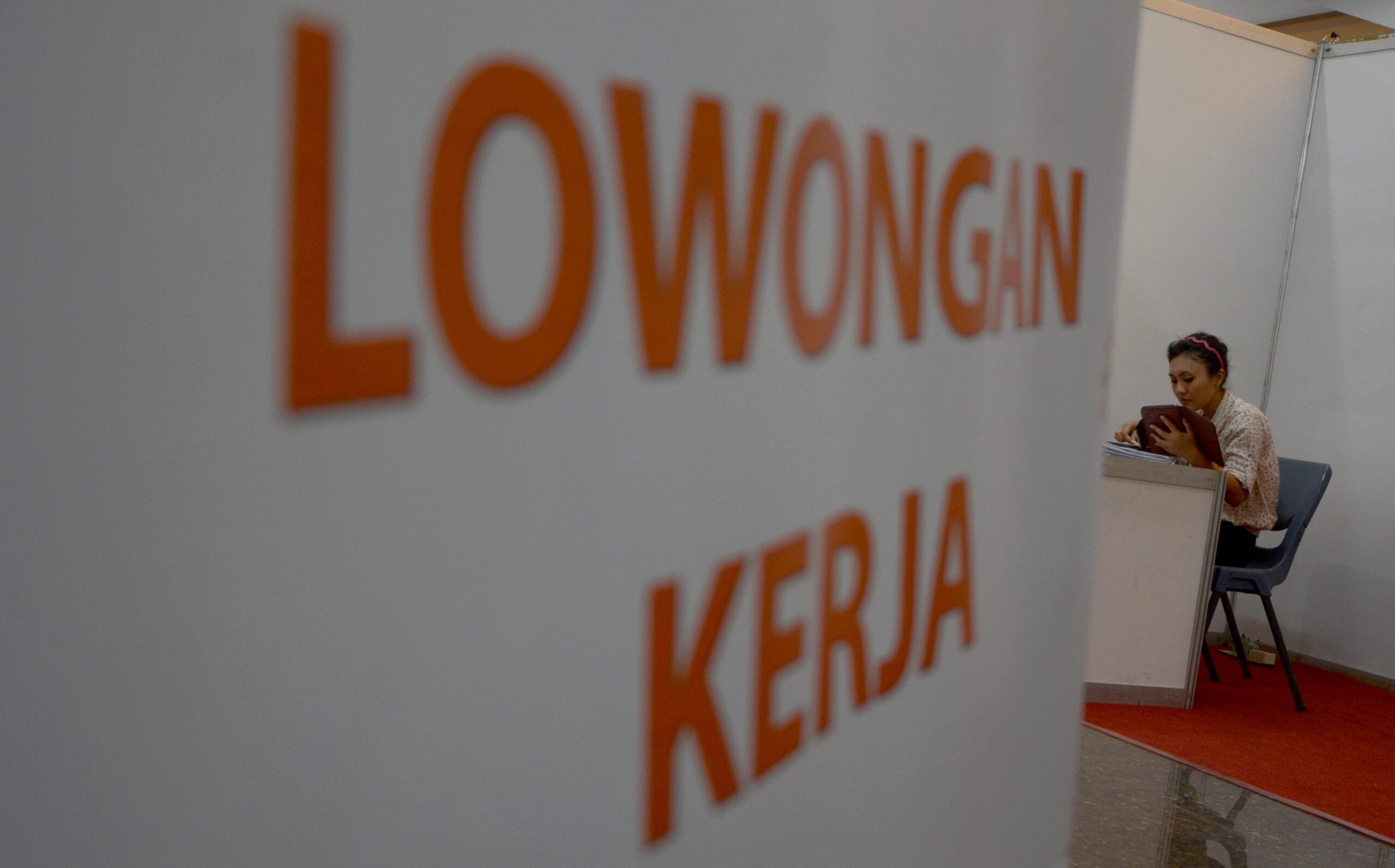 Rabu (30/10) Seorang petugas salah satu stand bursa tenaga kerja menunggu calon pelamar kerja di Islamic Vilage, Karawaci, Kabupaten Tangerang ( M JAKWAN)