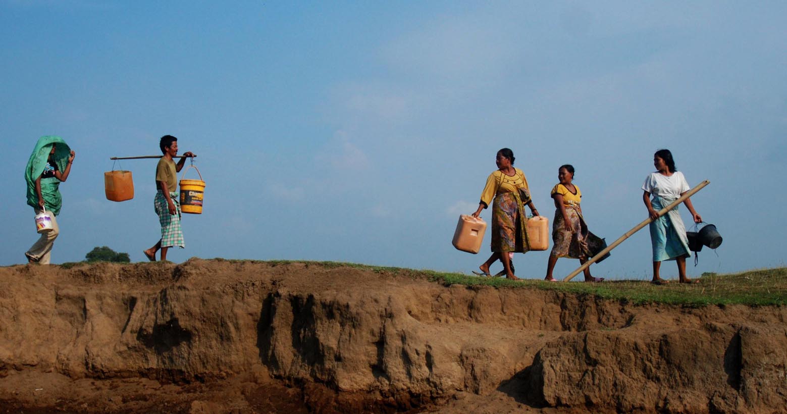 Warga Desa Lontar kecamatan Tirtayasa Kabupaten Serang-Banten berjalan beriringan untuk mengambil air yang jauh dari pemukiman dan mereka mengambil air dari sumur kecil yang mereka gali sendiri (M JAKWAN/RADAR BANTEN)