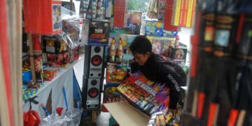Amirudin (25) menata kembang api dagangannya yang berada di Jalan Kisamaun, Pasar Lama, Kota Tangerang.Jumat (28/12) Kembang api dengan harga dari puluhan ribu hingga jutaan rupiah menjelang pergantian tahun banyak diburu warga (M JAKWAN)