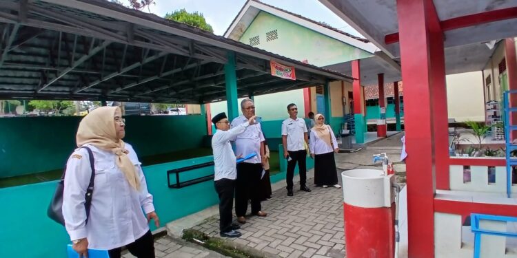 Penilai saat meninjau sarana cuci tangan dan tempat sampah terpilah di SDIT Bina Insani, Selasa (10/12/2025). Foto: Dok. Sekolah.
